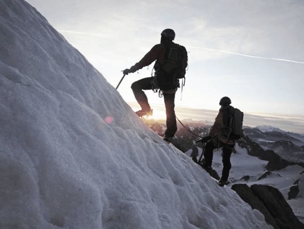 Deux hommes grimpant une montagne enneigée
